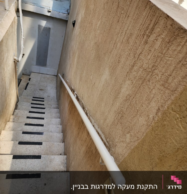 מדרגות עם מעקה לבן וקיר בצבע בז